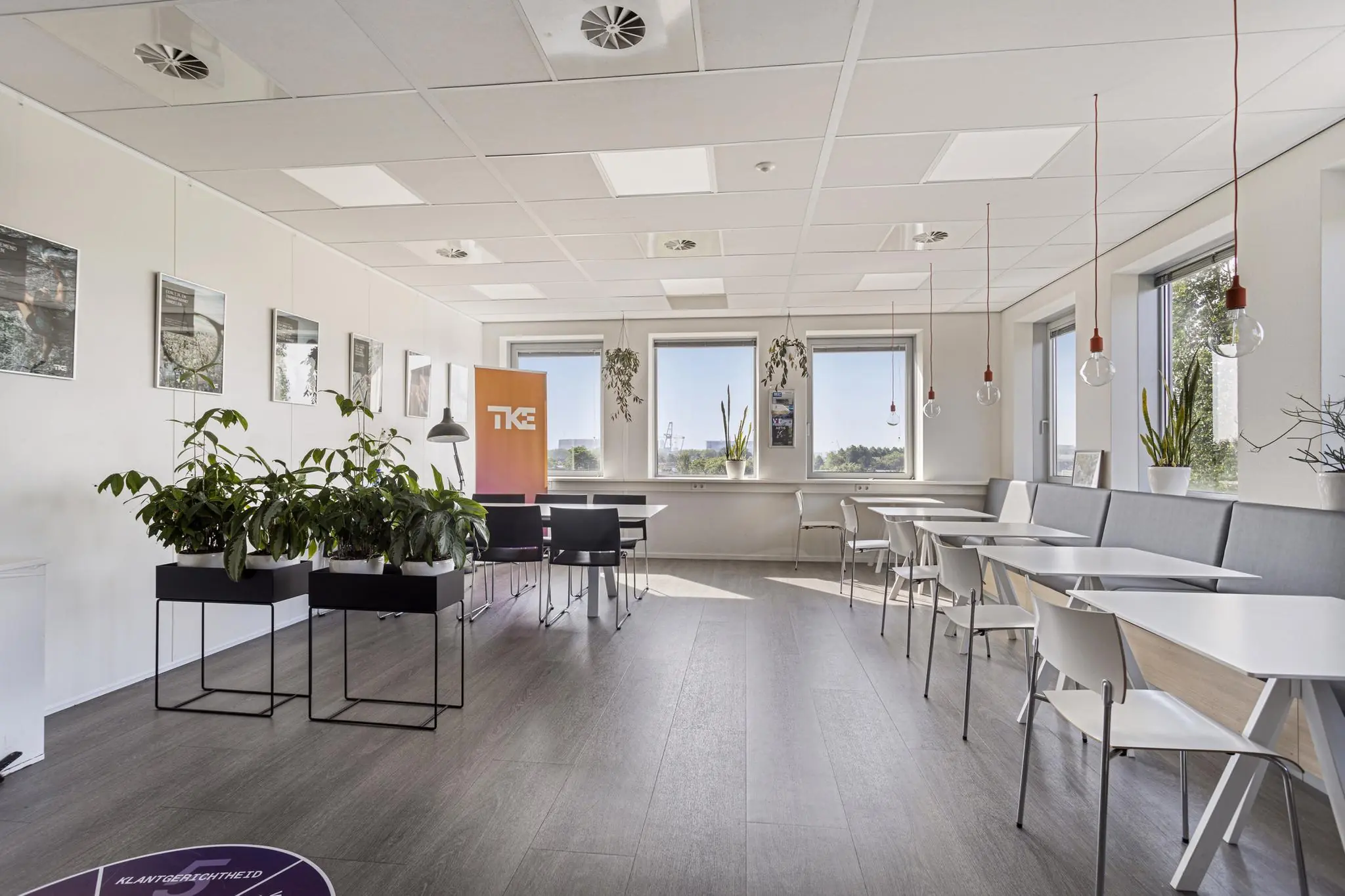 Moderne en lichte kantoorruimte aan de Fascinatio Boulevard met zitgedeelte, planten en grote ramen.